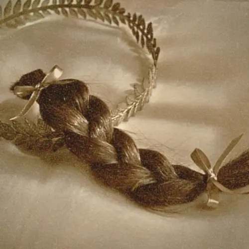 Braided lock of human hair tied with ribbons, preserved as a mourning keepsake.